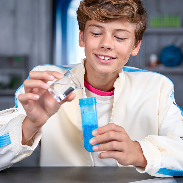 Boy mixing water in a test tube for MrBeast Lab Swarms experiment, showcasing fun and excitement.